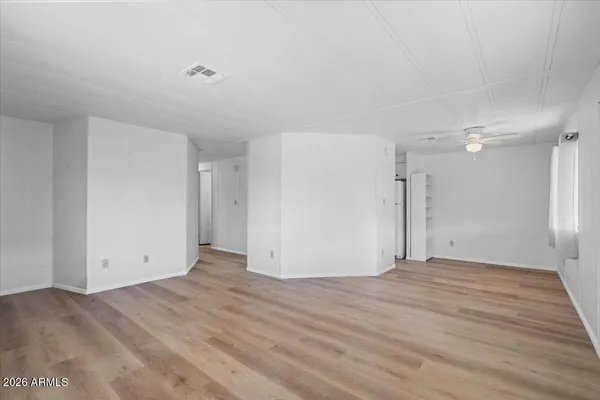 a view of an empty room with wooden floor
