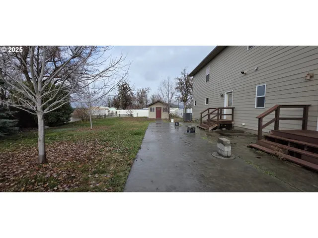 a backyard of a house with garden barbeque oven and outdoor seating