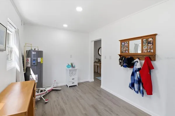 a view of an empty room with window and hardwood floor