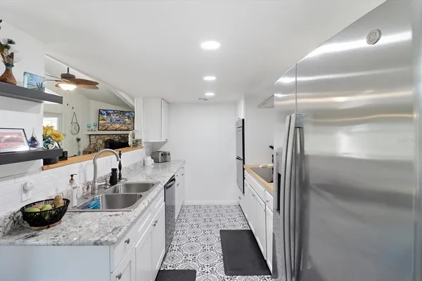 a kitchen with granite countertop a sink stove and refrigerator