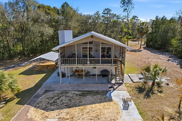 an aerial view of residential houses with outdoor space and trees