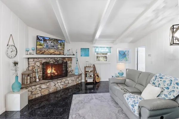 a living room with furniture a fireplace and a flat screen tv