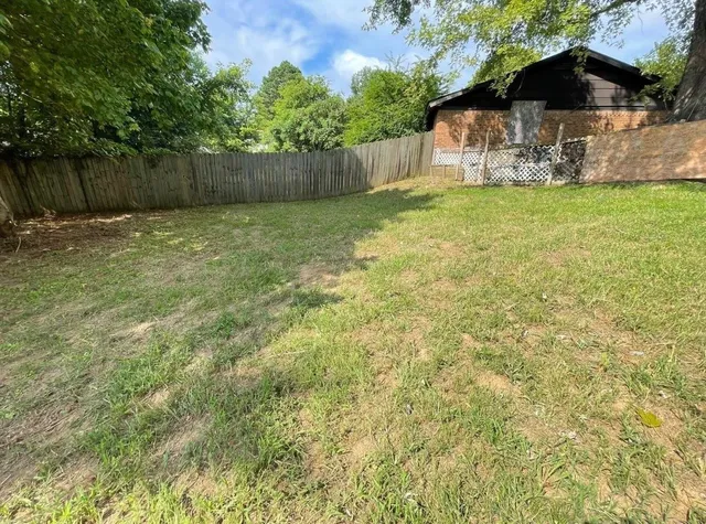 a backyard of a house with lots of plants and tree