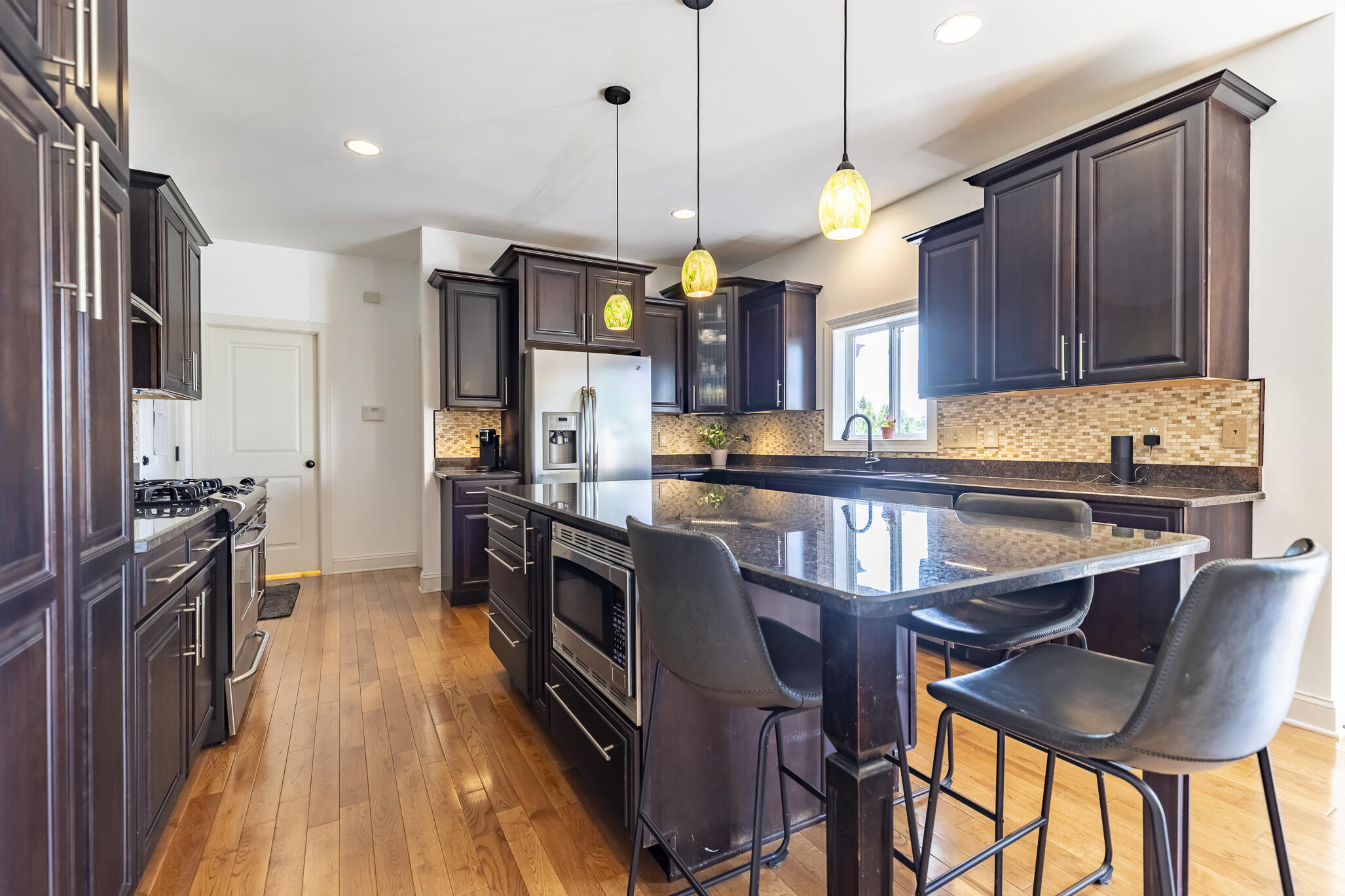 12492 Washington Street Crown Point, IN 46307 - Photo 9 of 43 a kitchen with granite countertop a table chairs stainless steel appliances and cabinets