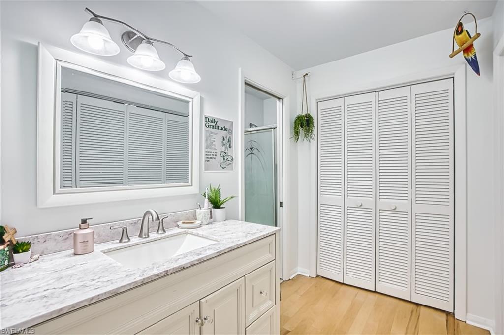 1210 Shady Rest Lane, Unit 14 Naples, FL 34103 - Photo 21 of 30 a bathroom with a granite countertop sink and a mirror