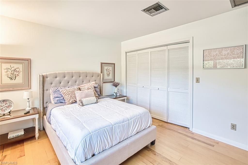 1210 Shady Rest Lane, Unit 14 Naples, FL 34103 - Photo 25 of 30 a bedroom with a bed and a lamp on the dresser