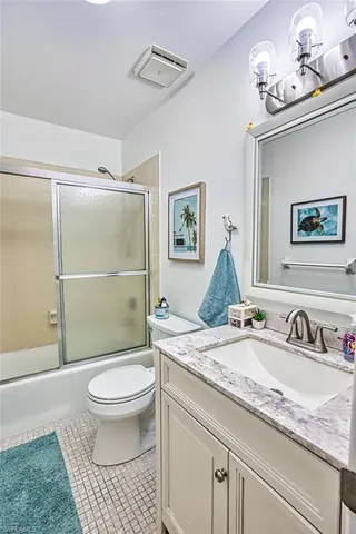 a bathroom with a granite countertop sink toilet a mirror and shower