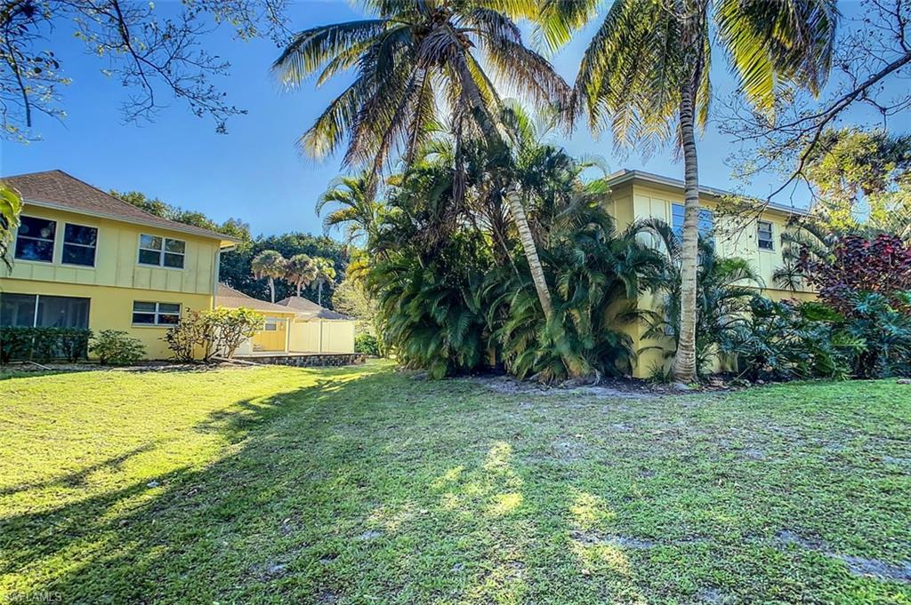 1210 Shady Rest Lane, Unit 14 Naples, FL 34103 - Photo 28 of 30 a view of a house with a yard and palm trees
