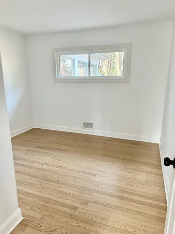 a view of a room with wooden floor and window