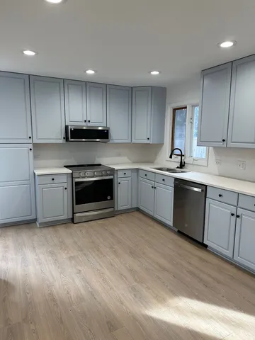 a kitchen with stainless steel appliances granite countertop a stove a sink dishwasher and a refrigerator