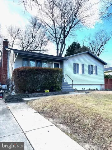 a view of a house with a yard covered with large trees