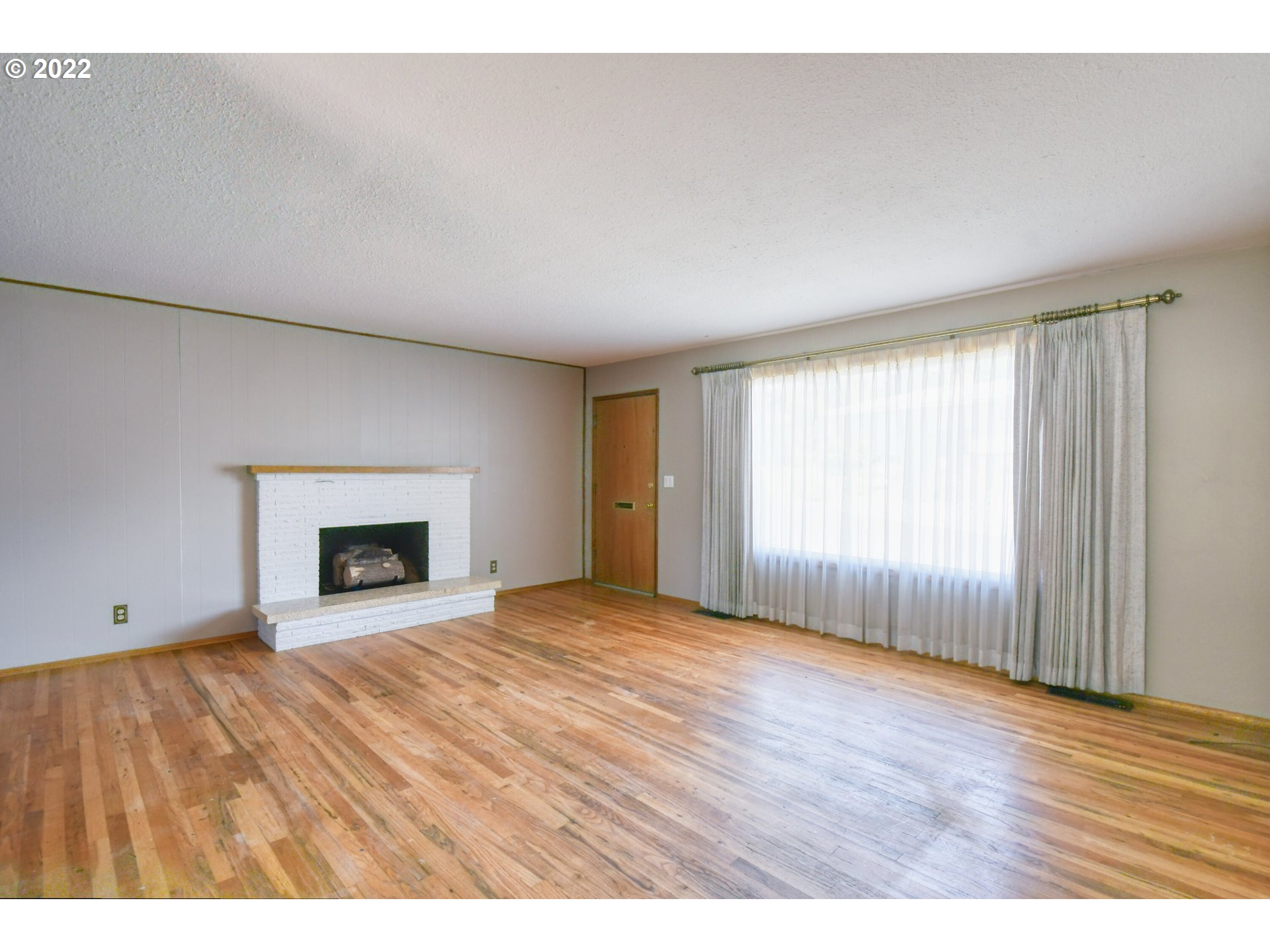 3231 Southwest Isaac Avenue Pendleton, OR 97801 - Photo 12 of 32 a view of empty room with wooden floor and fireplace