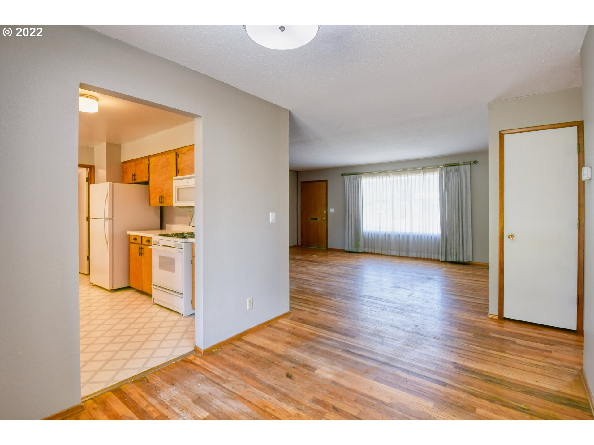 3231 Southwest Isaac Avenue Pendleton, OR 97801 - Photo 13 of 32 a view of empty room with wooden floor and kitchen view