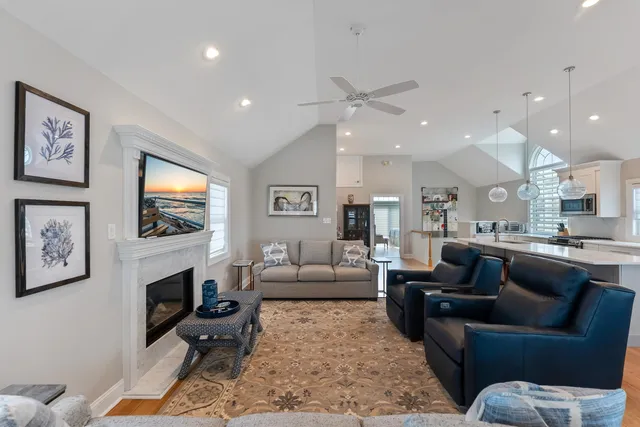 a living room with furniture a flat screen tv and a fireplace
