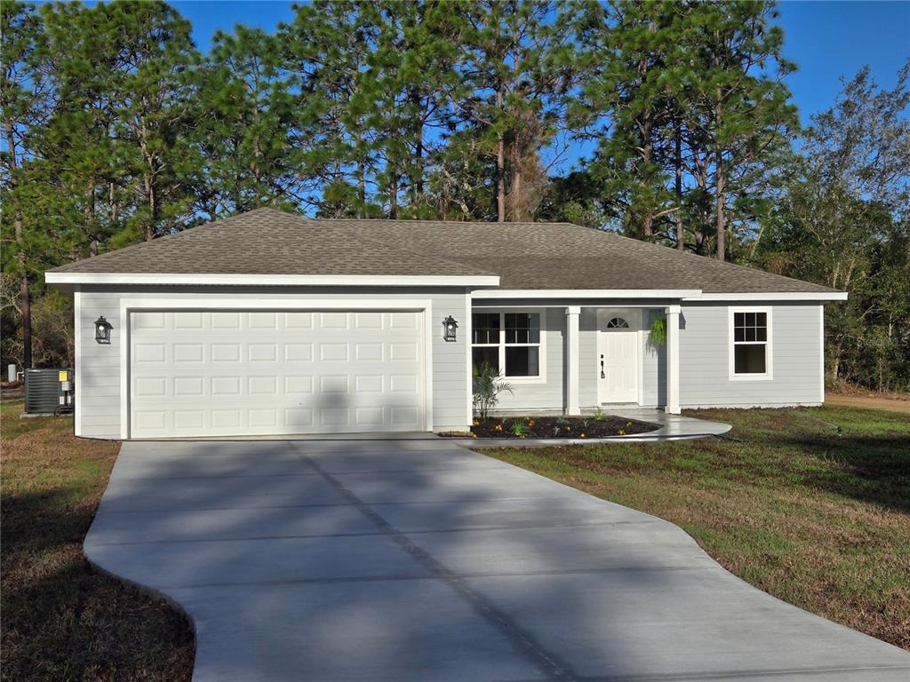 2988 Southwest Bonable Drive Dunnellon, FL 34431 - Photo 1 of 22 a front view of a house with a yard and garage
