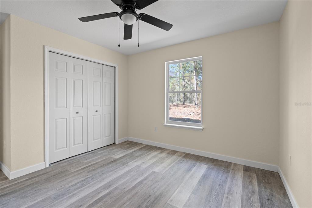2988 Southwest Bonable Drive Dunnellon, FL 34431 - Photo 12 of 22 a view of an empty room with wooden floor and a window