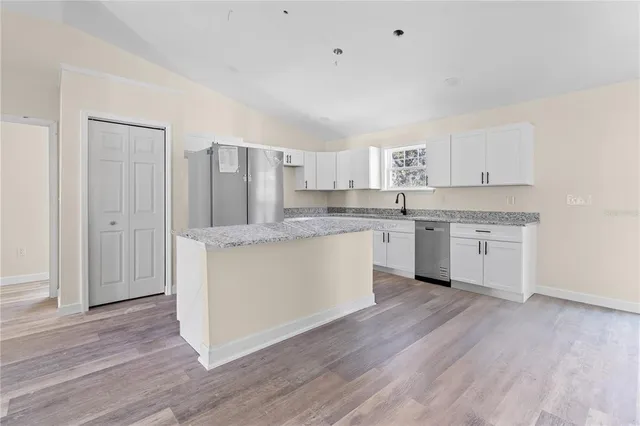 a kitchen with granite countertop white cabinets and white appliances