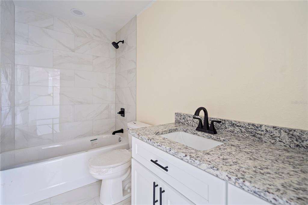 2988 Southwest Bonable Drive Dunnellon, FL 34431 - Photo 8 of 22 a bathroom with a granite countertop sink toilet and shower