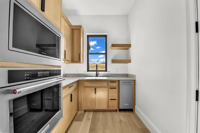 a kitchen with stainless steel appliances a stove microwave and sink