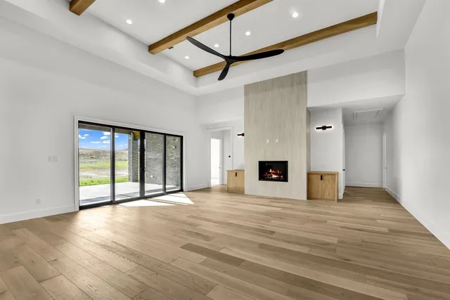 a view of an empty room with a fireplace and a window