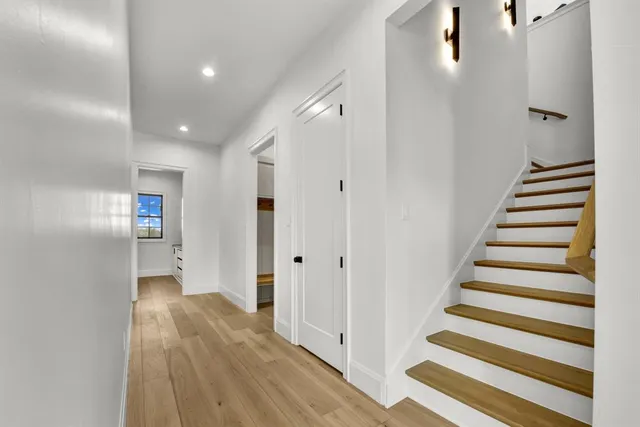 a view of a hallway with wooden floor and entryway