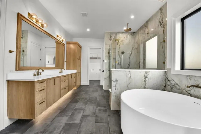 a bathroom with a double vanity sink mirror double and bathtub