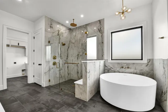 a bathroom with a tub sink shower and mirror