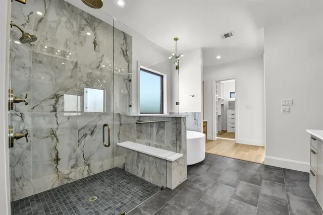 a spacious bathroom with a double vanity sink a toilet a mirror and shower