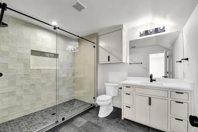 a bathroom with a double vanity sink mirror and toilet
