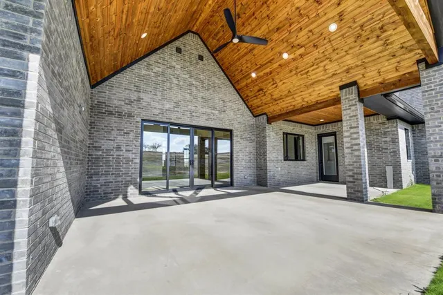 a view of a patio with a table and chairs and wooden fence