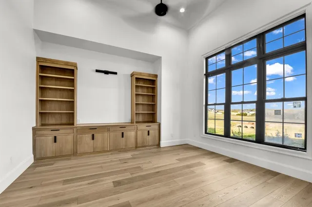 an empty room with cabinet and windows