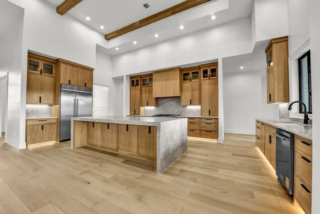 a large kitchen with stainless steel appliances wooden cabinets and a granite counter tops