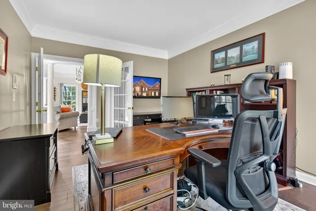 a large kitchen with stainless steel appliances kitchen island granite countertop a stove a sink a refrigerator and white cabinets with wooden floor