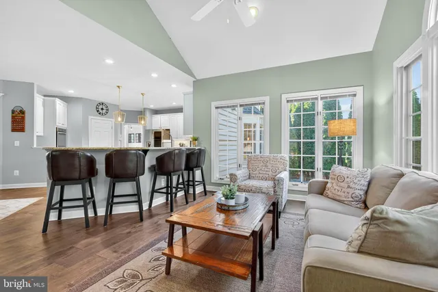 a living room with furniture a rug and a floor to ceiling window