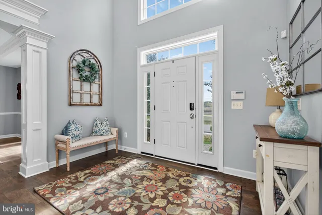 a view of a dining room and livingroom with furniture wooden floor a chandelier
