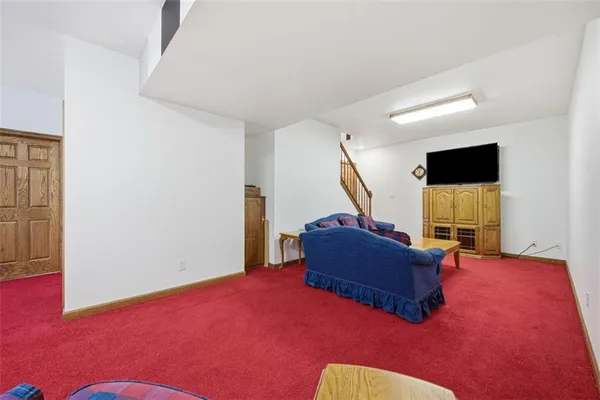 a view of a livingroom with a large window and kitchen view
