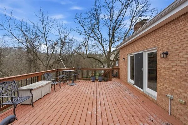 a view of a roof deck with table and chairs a barbeque with wooden floor and fence