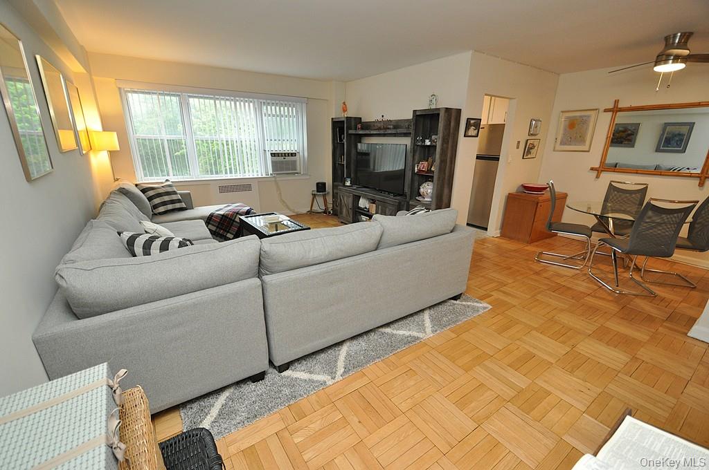 235 Garth Road, Unit A5B Scarsdale, NY 10583 - Photo 32 of 47 a living room with furniture window and a flat screen tv