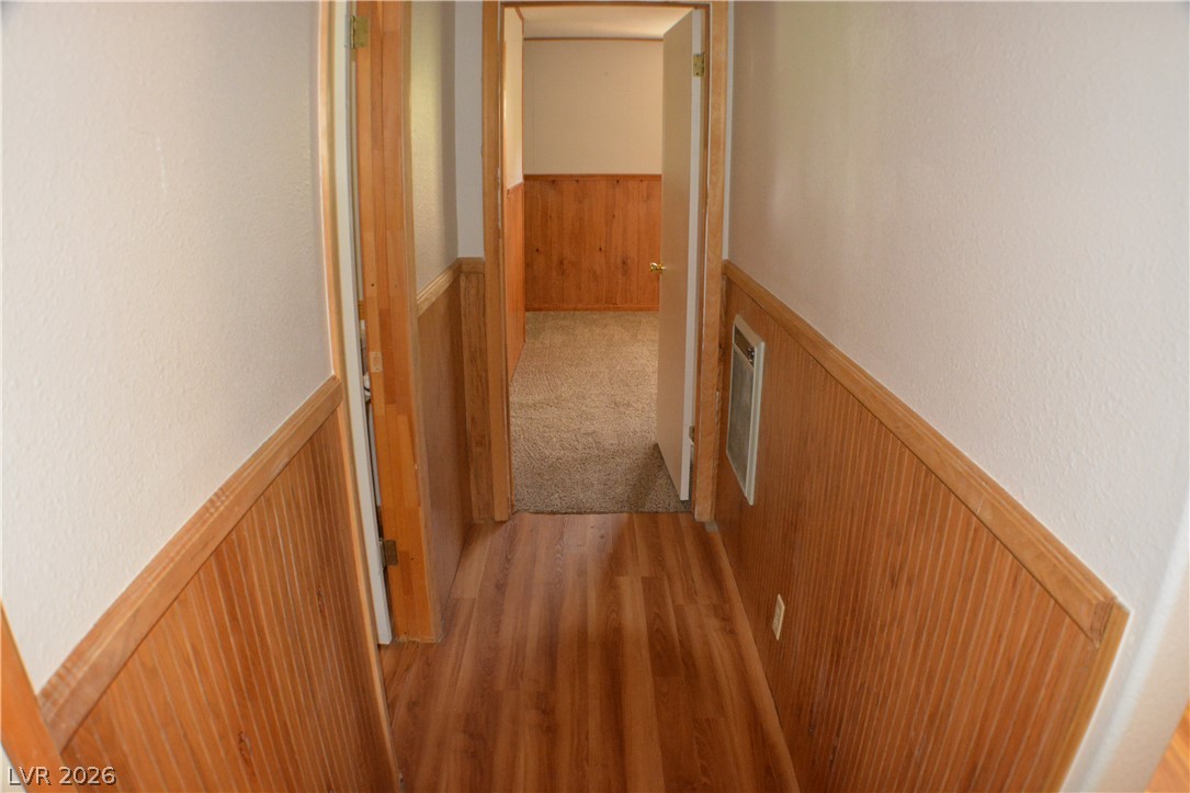 1321 Trout Canyon Road Las Vegas, NV 89124 - Photo 47 of 50 A warm wooden wainscoting details this welcoming hallway, leading to a plush carpeted space.