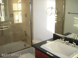 a bathroom with a sink double vanity mirror and a bathtub