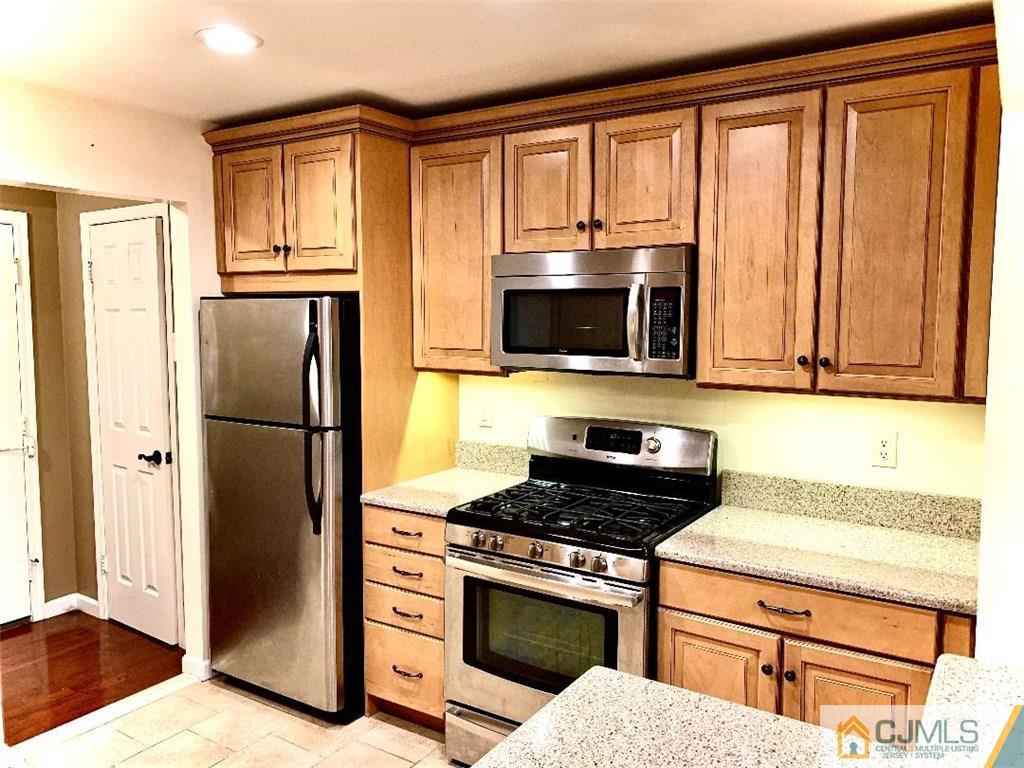 14 Kensington Road, Unit G Chatham, NJ 07928 - Photo 2 of 10 a kitchen with a refrigerator stove and microwave
