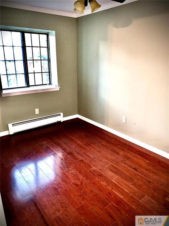 14 Kensington Road, Unit G Chatham, NJ 07928 - Photo 7 of 10 an empty room with wooden floor and windows