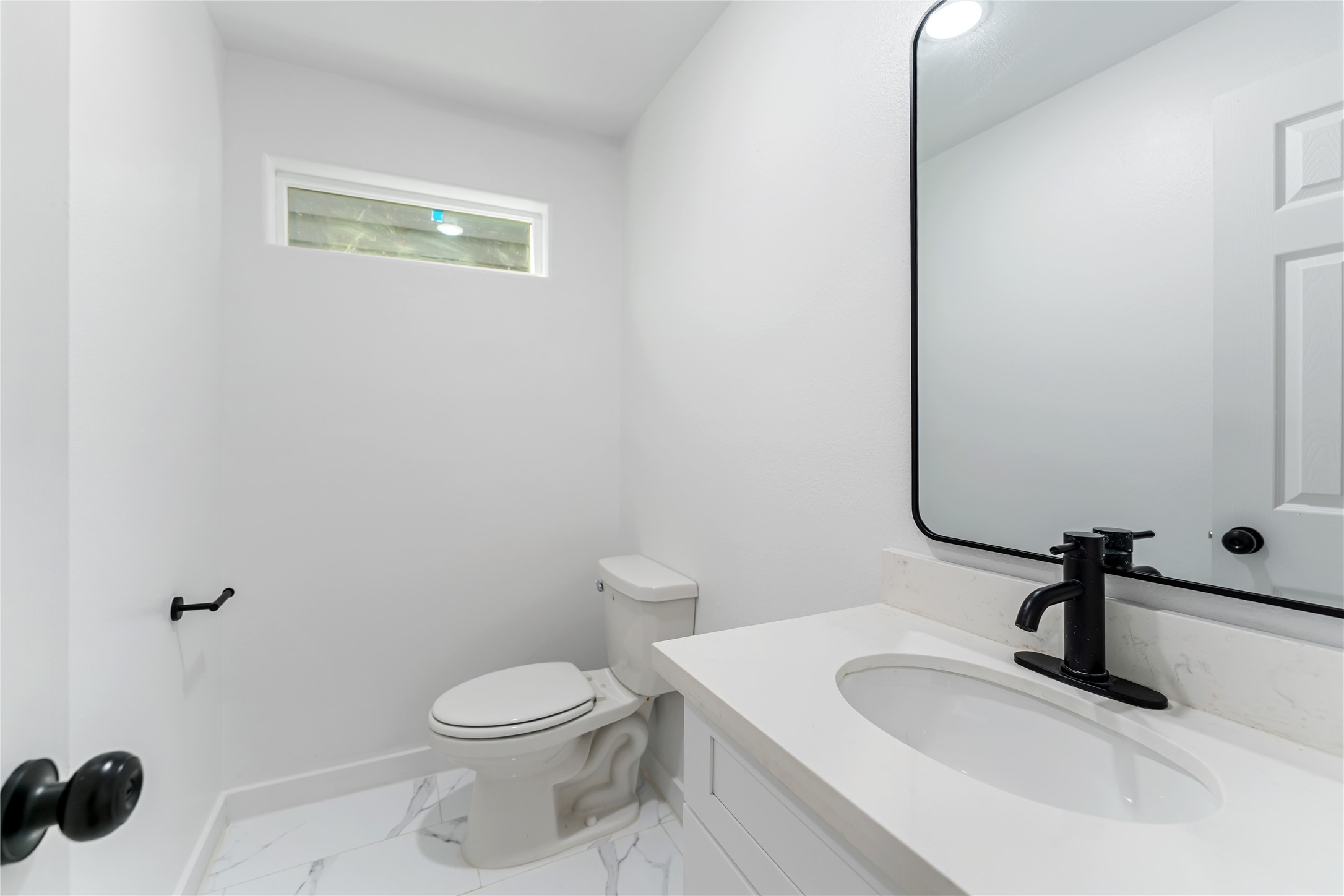 9326 Firnat Street Houston, TX 77016 - Photo 17 of 30 a bathroom with a sink a toilet and a mirror