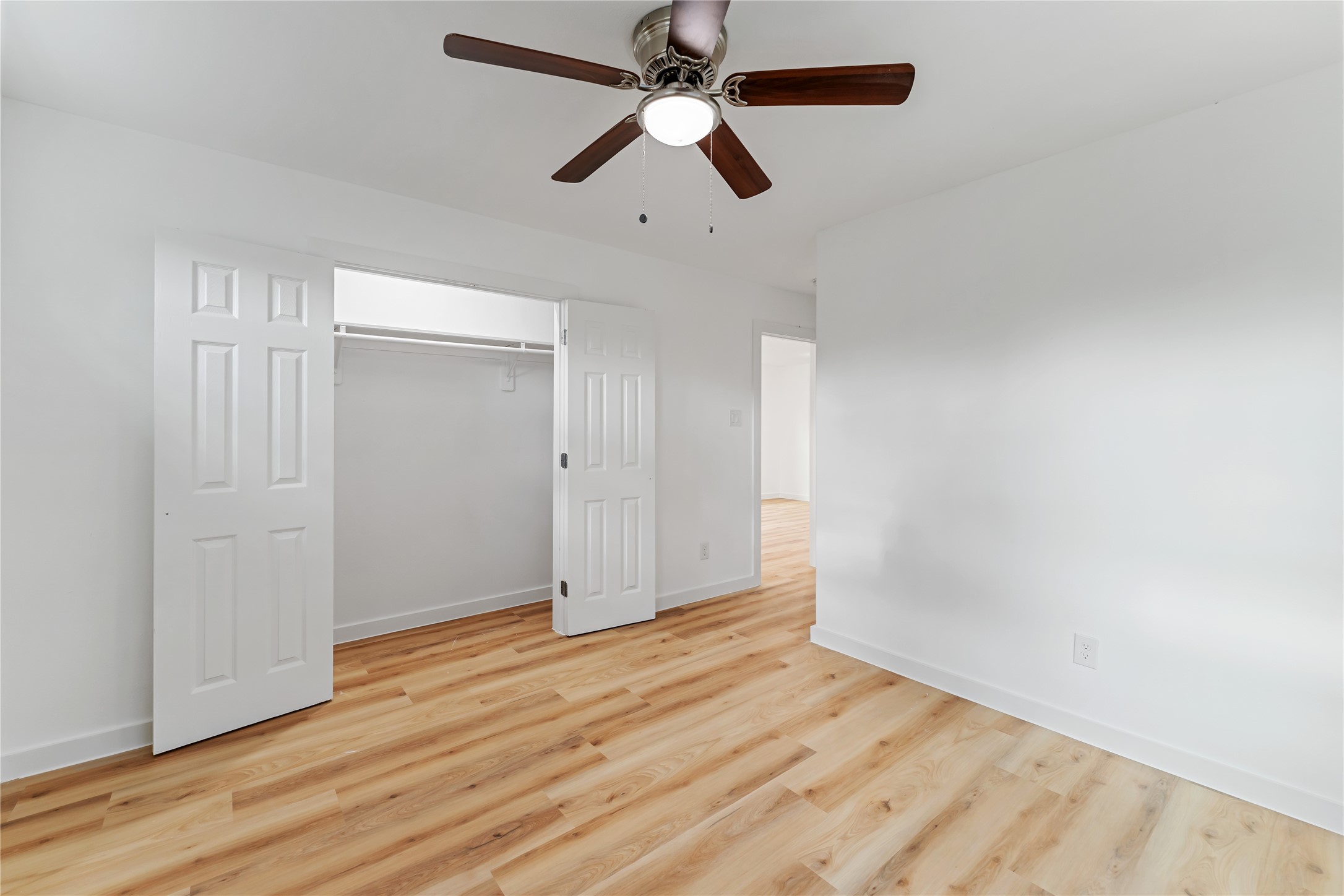 9326 Firnat Street Houston, TX 77016 - Photo 20 of 30 an empty room with wooden floor ceiling fan and window
