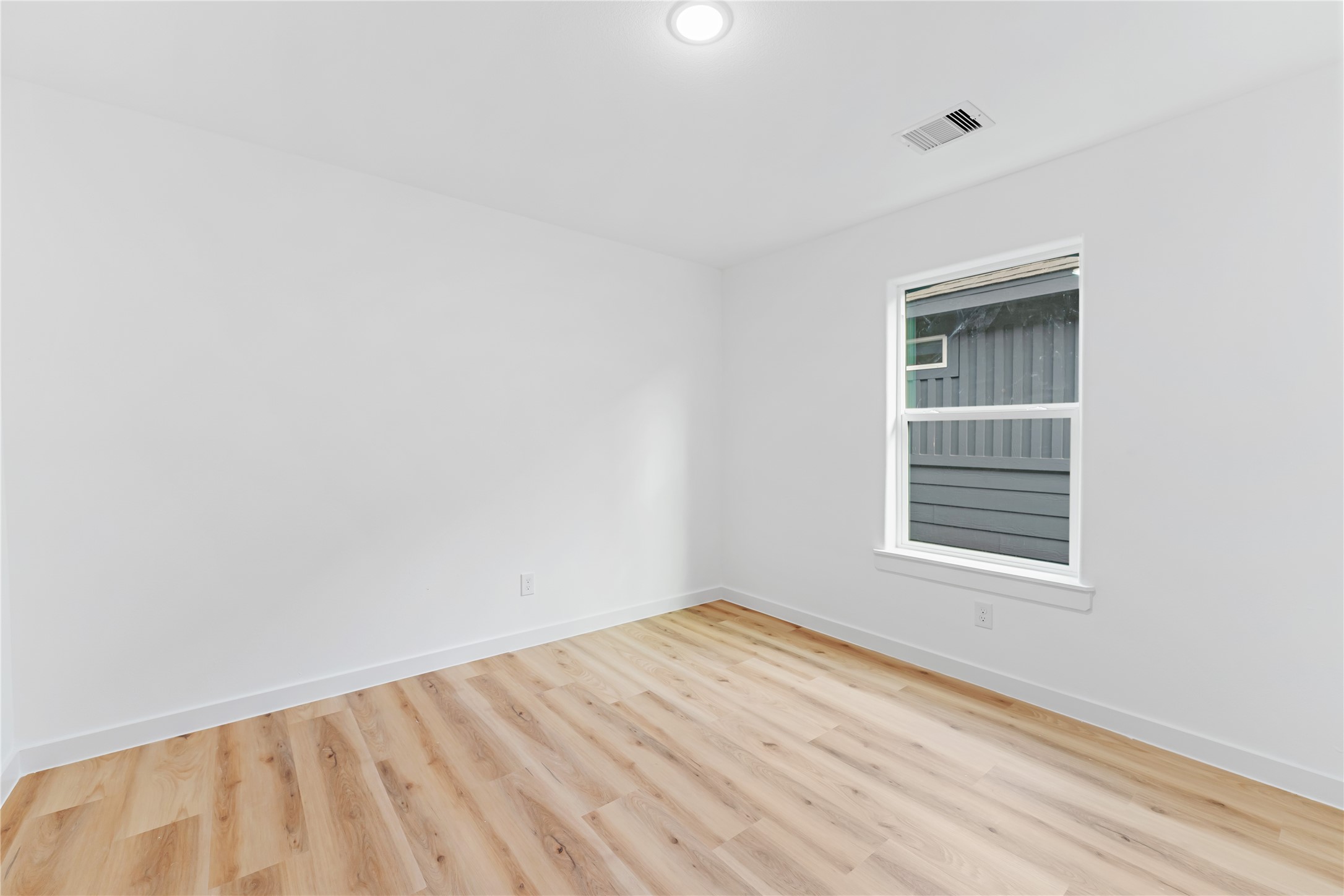 9326 Firnat Street Houston, TX 77016 - Photo 21 of 30 a view of an empty room with wooden floor and a window
