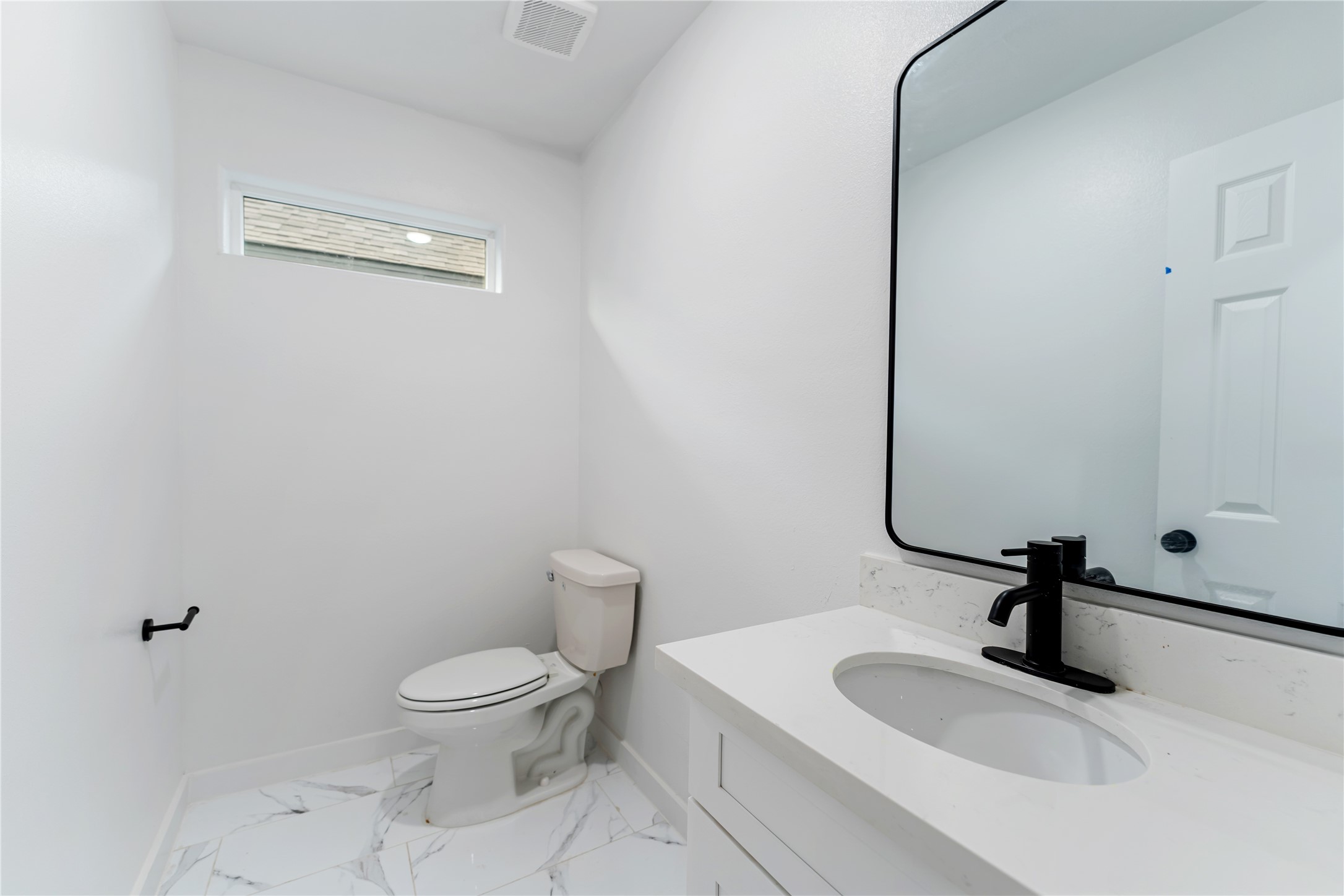 9326 Firnat Street Houston, TX 77016 - Photo 24 of 30 a bathroom with a sink a toilet and a mirror