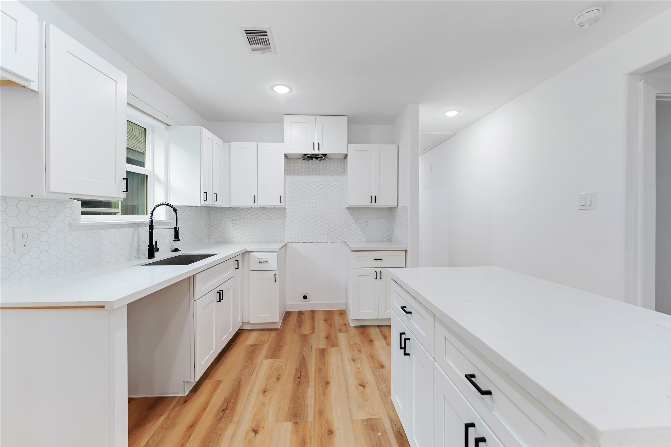 9326 Firnat Street Houston, TX 77016 - Photo 5 of 30 a kitchen with white cabinets sink and stove