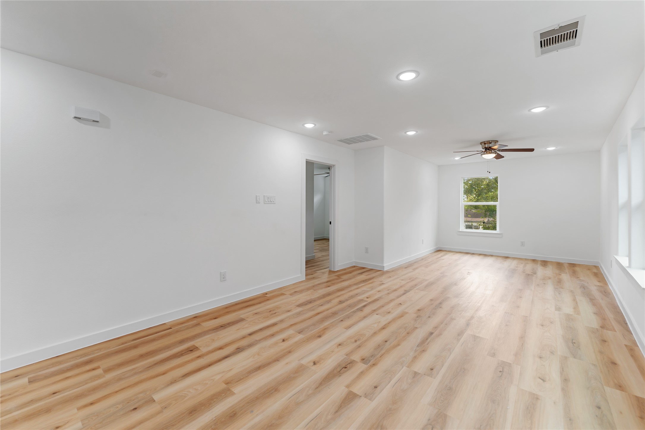 9326 Firnat Street Houston, TX 77016 - Photo 6 of 30 a view of an empty room with wooden floor and a window
