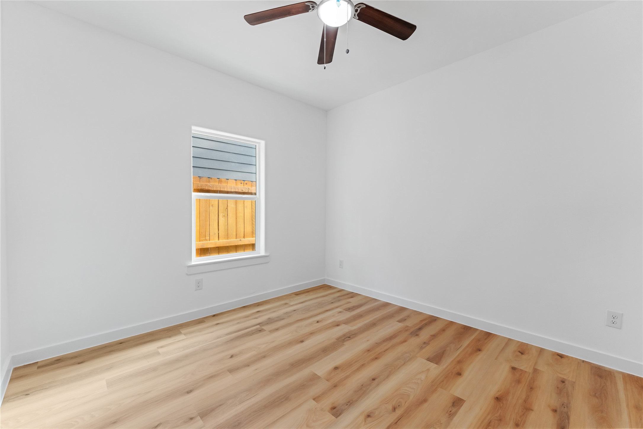 9326 Firnat Street Houston, TX 77016 - Photo 8 of 30 an empty room with a window and a ceiling fan