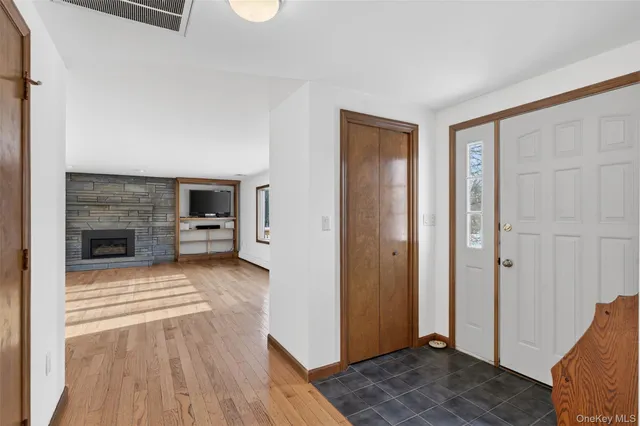 a view of a livingroom with wooden floor and kitchen space